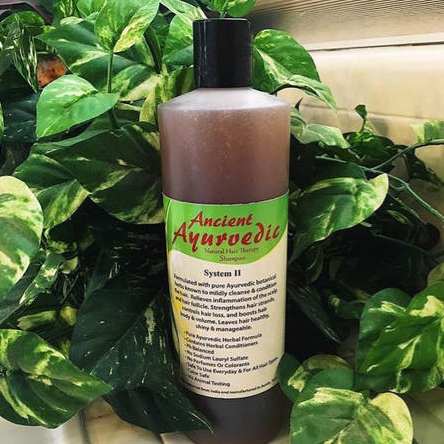 Bottle of Ancient Ayurvedic hair care product with green leaves in the background